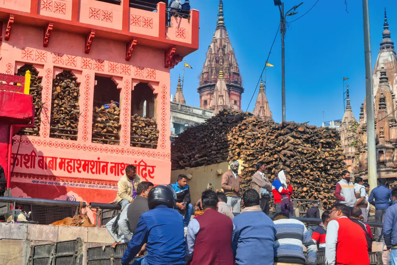 Temple structures and stacked ceremonial wood at Manikarnika Ghat in Varanasi